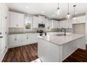 Modern kitchen featuring white cabinets, stainless steel appliances, granite countertops, and a spacious center island at 1874 Mcgarity Rd, Mcdonough, GA 30252