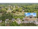 Beautiful aerial view of the home in a lush neighborhood, close to a golf course, and surrounded by trees at 124 Grand Oaks Dr, Canton, GA 30115