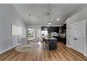 Open floor plan featuring a dining room with modern light fixtures, wood floors, and island with seating at Lot 1 Perkins Rd, Dallas, GA 30157