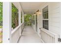 Long, white, covered front porch with gray flooring and white railings, with exterior lights at 1555 New Ne St, Atlanta, GA 30307