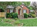 Quaint brick home featuring stone steps, a red door, and manicured greenery at 1798 Melrose Sw Dr, Atlanta, GA 30310