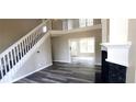 Bright, airy living room features high ceilings, modern flooring, and fireplace, with stairs to the second floor at 60 Whispering Pine Ct, Covington, GA 30016