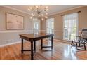 Elegant dining room featuring hardwood floors, a modern light fixture, and large windows with natural light at 130 Brandon Mill Cir, Fayetteville, GA 30214