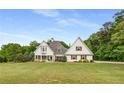 Charming two-story home with a manicured front lawn and mature trees in the background at 300 Massengale Rd, Brooks, GA 30205