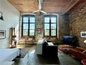 Inviting living room boasts exposed brick, high ceilings, and abundant natural light from large windows at 170 Boulevard Se # H301, Atlanta, GA 30312
