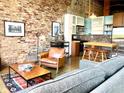 Open concept living area with exposed brick, modern kitchen, and comfortable seating at 170 Boulevard Se # H301, Atlanta, GA 30312