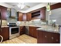 Modern kitchen with stainless steel appliances, dark wood cabinets, mosaic backsplash, and granite countertops at 1350 Overlook Se Cv, Smyrna, GA 30080