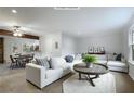 Bright, open living room featuring a white sofa, round wood coffee table, and views into the dining area at 1350 Overlook Se Cv, Smyrna, GA 30080