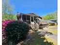 Back exterior view featuring a wooden deck and well landscaped yard at 4457 Huntshire Dr, Stone Mountain, GA 30083