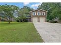 Traditional two-story house featuring a well-maintained lawn and double garage doors at 4457 Huntshire Dr, Stone Mountain, GA 30083