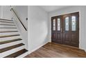 Bright foyer featuring hardwood floors, stairs, and a beautifully designed front door at 4457 Huntshire Dr, Stone Mountain, GA 30083
