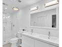 Clean, all white bathroom featuring double vanity, large mirror, and a glass-enclosed shower at 11 Ardmore Nw Sq, Atlanta, GA 30309