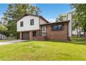 Charming two-story home with white siding, brick accents, a driveway, and an attached garage in a lush, green neighborhood at 2469 Silver King Dr, Grayson, GA 30017