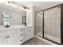 Modern bathroom with a double vanity, sleek black fixtures, and glass shower door at 4663 Larkfield Way, Powder Springs, GA 30127
