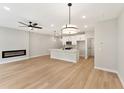 Modern living room and kitchen features light hardwood floors and a cozy fireplace at 4663 Larkfield Way, Powder Springs, GA 30127