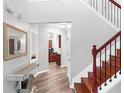 Inviting foyer with hardwood floors, elegant staircase, decorative mirror, and views into the kitchen at 5645 Carrington Pl, Cumming, GA 30040