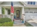 Inviting front porch with an American flag and stone columns with a view of the two car garage at 2686 Oak Leaf Se Pl, Atlanta, GA 30316