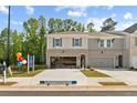 Daytime view of new townhome with brick accents, two-car garage, and attractive landscaping in a suburban setting at 4667 Larkfield Way, Powder Springs, GA 30127