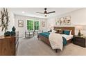 Cozy bedroom with neutral palette, accent pillows, ceiling fan and a sunny window overlooking trees at 4667 Larkfield Way, Powder Springs, GA 30127