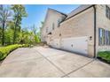 Spacious driveway leading to a three-car garage with a basketball hoop in the background at 5335 Briarstone Ridge Way, Alpharetta, GA 30022