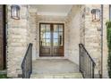 Inviting entryway featuring double doors, stone accents, and decorative lighting fixtures at 5335 Briarstone Ridge Way, Alpharetta, GA 30022