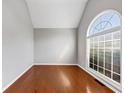 Well-lit living room with hardwood floors, a large arched window, and neutral paint at 566 Vintage Pointe Run, Mableton, GA 30126