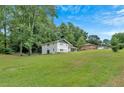 Expansive backyard featuring lush green grass and mature trees, perfect for outdoor activities at 1520 Oxford St, Douglasville, GA 30134