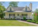 Inviting home with a covered porch, lovely lawn, and charming details, surrounded by lush landscaping at 780 Old Magnolia Trl, Canton, GA 30115