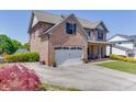 Brick-clad home with attached garage, long driveway, and well-manicured lawn at 55 Sudderth St, Buford, GA 30518