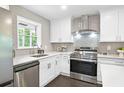 Modern kitchen featuring stainless steel appliances, white cabinets, and a stylish backsplash at 1140 Starline Se Dr, Smyrna, GA 30080