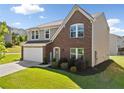 Charming two-story home showcasing a brick and siding facade, well-manicured lawn, and a two-car garage at 1560 Avalon Creek Rd, Sugar Hill, GA 30518