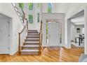 Bright and airy foyer with hardwood floors, a staircase, and large windows that flood the space with natural light at 5303 Davenport Mnr, Cumming, GA 30041