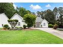 Charming single-story home boasts lush landscaping, a well-manicured lawn, and a welcoming facade at 5042 Southland Dr, Woodstock, GA 30188