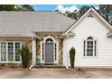 Close-up of the front entrance of the house, featuring stone accents and an arched doorway at 5042 Southland Dr, Woodstock, GA 30188