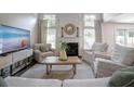 Bright living room featuring a fireplace, large windows, neutral décor, and comfortable seating at 6030 Pattingham Dr, Roswell, GA 30075