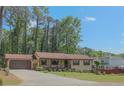 Ranch style home with a covered porch and large front yard lined with trees and green grass at 3814 Lamar Way, Snellville, GA 30039