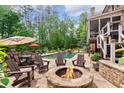 Expansive backyard featuring an outdoor fireplace, dining set, and a gunite pool and spa at 5475 Copper Creek Pass, Cumming, GA 30040