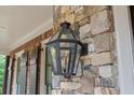 Close up of exterior light fixture on stone and brick home, showing natural light and architectural interest at 5475 Copper Creek Pass, Cumming, GA 30040
