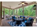 Cozy screened porch with comfortable seating, ceiling fans, and views of the private wooded backyard at 5475 Copper Creek Pass, Cumming, GA 30040
