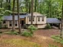 Attractive exterior featuring two-tone siding, stone accents, covered parking and mature shade trees at 203 Concorde Sw Way, Lilburn, GA 30047