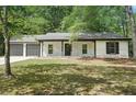 Front of the house with stone accents, a two-car garage, and a lush green lawn at 250 Huntcliff Ct, Fayetteville, GA 30214