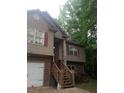 Two story home with tan siding, brick facade, red shutters, and wooden staircase at 143 Delane Dr, Dallas, GA 30157