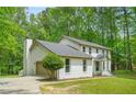 Side view of a white brick home with attached garage, mature landscaping, and gray roof at 230 Deer Forest Rd, Fayetteville, GA 30214
