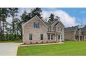 A lovely brick home with green shutters, set on a spacious lawn, surrounded by mature trees at 322 Delta Dr, Mcdonough, GA 30253
