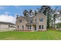 Beautiful brick home featuring a large green lawn and complemented by lush trees at 322 Delta Dr, Mcdonough, GA 30253