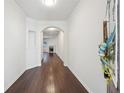 Hallway with hardwood floors, white walls, and an arched entryway leading to the living area at 6071 Apple Grove Rd, Buford, GA 30519