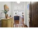 Elegant entryway featuring hardwood floors, decorative art, and a glimpse into the modern kitchen and dining area at 214 Vickery Falls Dr, Roswell, GA 30075