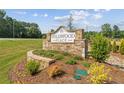 Stone entrance sign for Wildwood Place neighborhood on a sunny day with beautifully maintained landscaping at 4655 Larkfield Way, Powder Springs, GA 30127