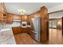 Cozy kitchen boasts wood cabinetry, stainless steel appliances, granite countertops, and warm wood flooring at 1190 Hess Dr, Avondale Estates, GA 30002