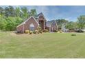 Expansive front yard showcases a stately brick home with well-maintained shrubbery at 2417 Saint Feagin Pl, Powder Springs, GA 30127
